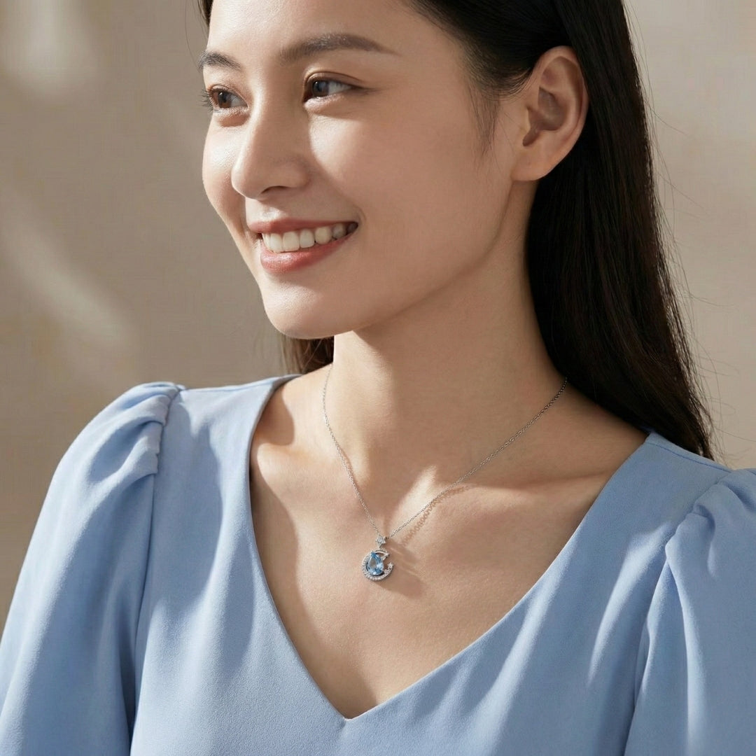 The Moondust Whisper Necklace captures the ethereal beauty of a moonlit sky, featuring a mesmerizing blue water-drop stone nestled within a delicate celestial crescent. It brings a sophisticated sense of wonder to any look.